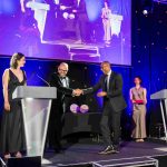 Colin Jackson walking across the stage and shaking hands with presenter Tim Rhys Evans