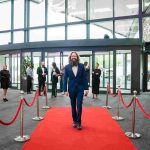 A person walking down a red carpet and smiling